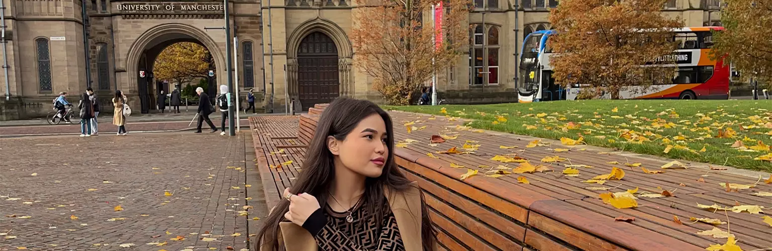 Zhansaya Kenzhegariyeva sitting on a bench on Brunswick Park