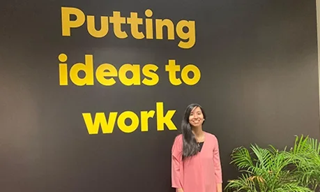 girl in front of sign at work