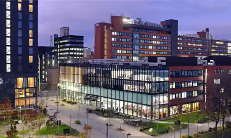 The Alliance Manchester Business School building on the busy Oxford Road in Manchester