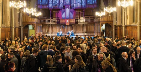 A crowd of people at a conference in a big church hall