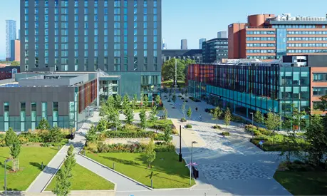 The Alliance Manchester Business School building, Executive Education Centre and Hyatt Hotel on campus in the daylight.