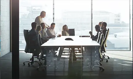 CEO giving peptalk to businesspeople at meeting in big conference room.