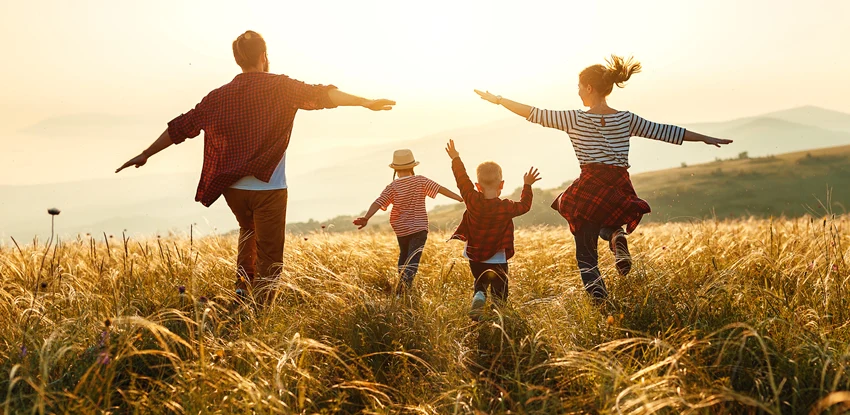 Happy family: mother, father, children son and daughter on nature on sunset.
