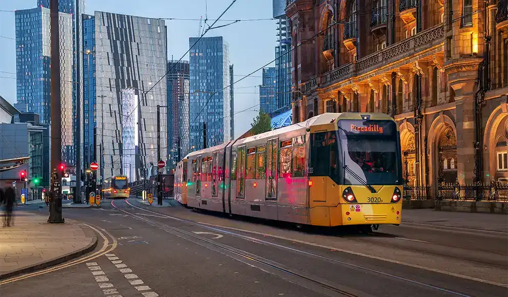A yellow tram crossing through Manchester city centre