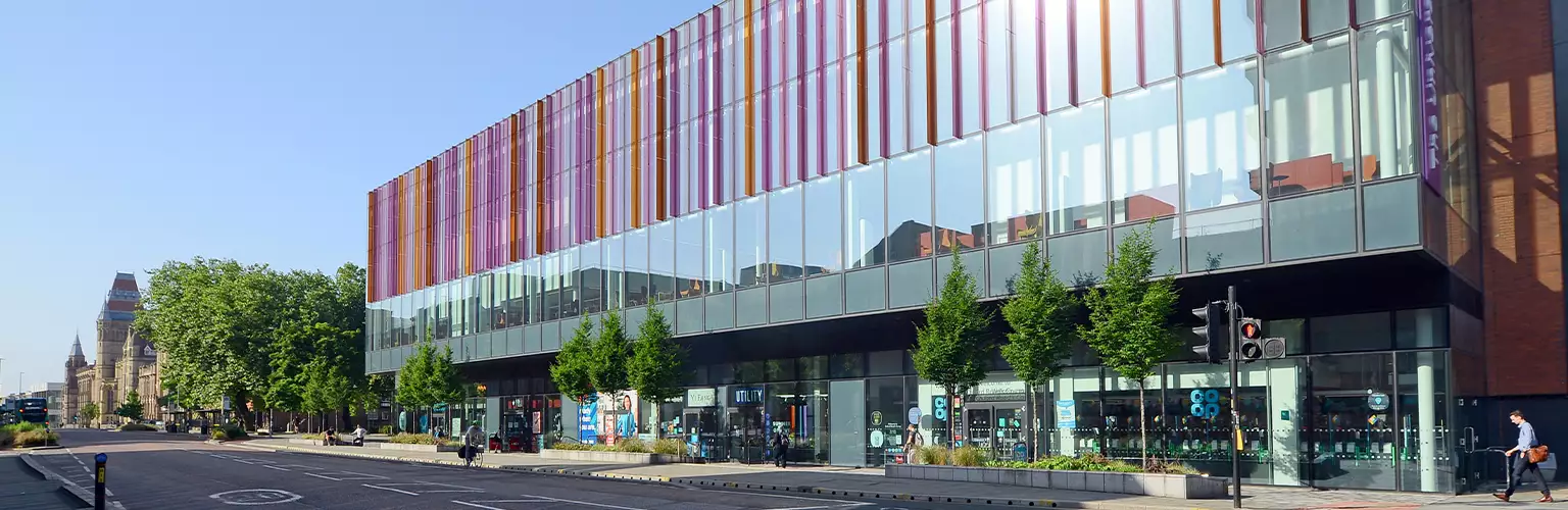 A photo of the Alliance Manchester Business School building looking towards the road leading to the main University of Manchester campus