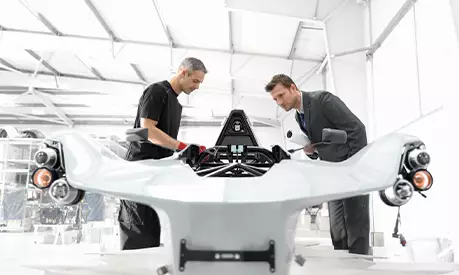 Two men looking at a newly built car