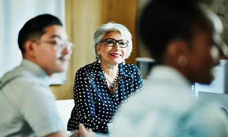 An older woman sitting in a meeting