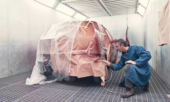 A man spray painting a car