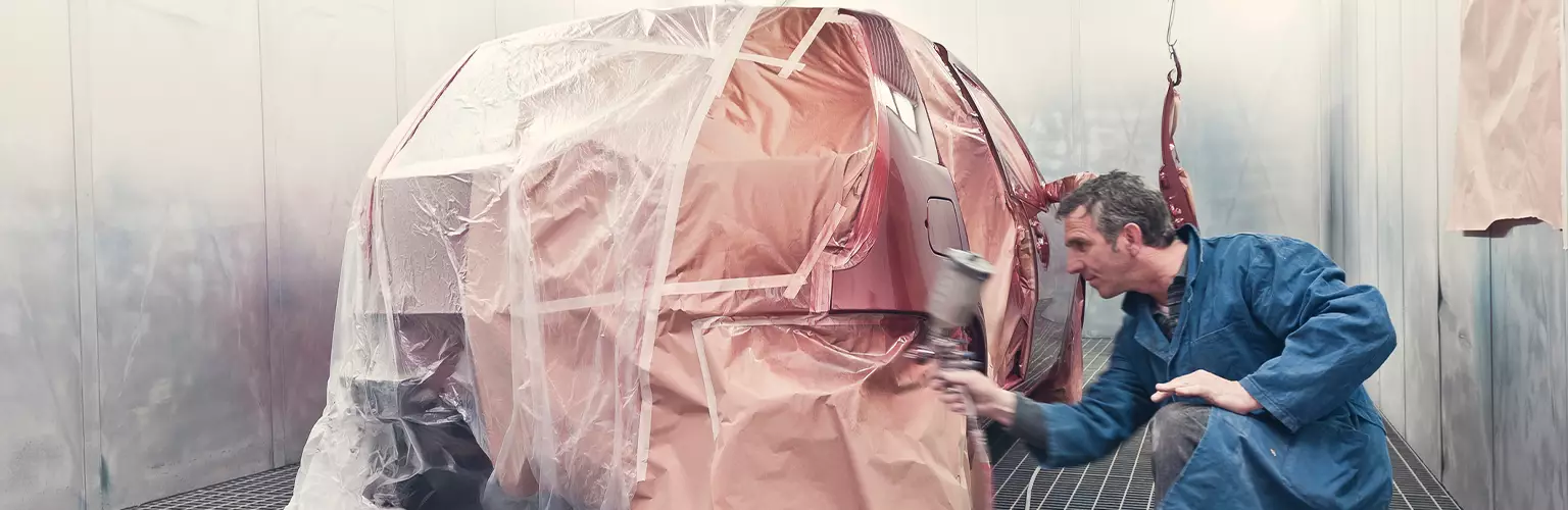 A man spray painting a car