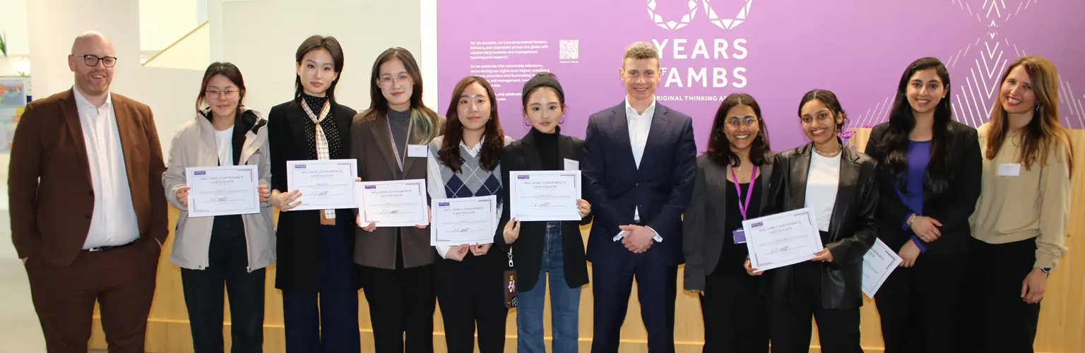A group of HR master's students standing with some HR professionals and holding certificates.