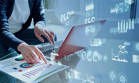 A pair of hands working on a laptop computer with digital images surrounding