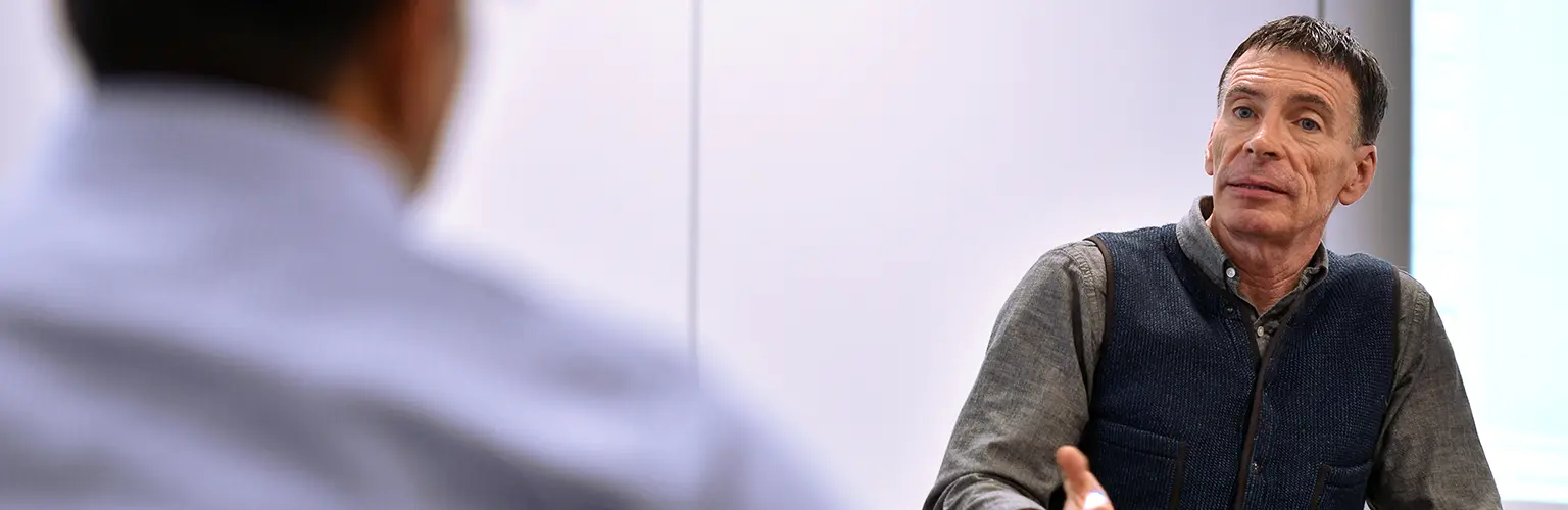 An academic professor teaching at the front of a classroom