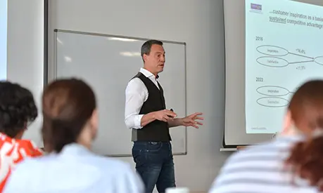 An academic professor teaching at the front of a classroom