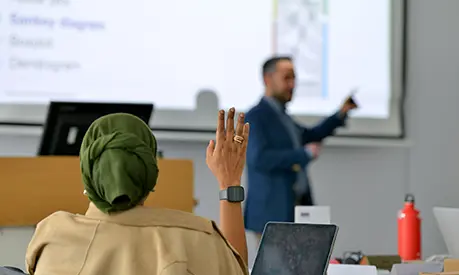 An academic professor teaching at the front of a classroom